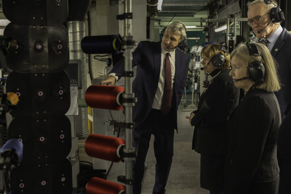 Julius Walters showing Lady Clare a loom on the weaving floor