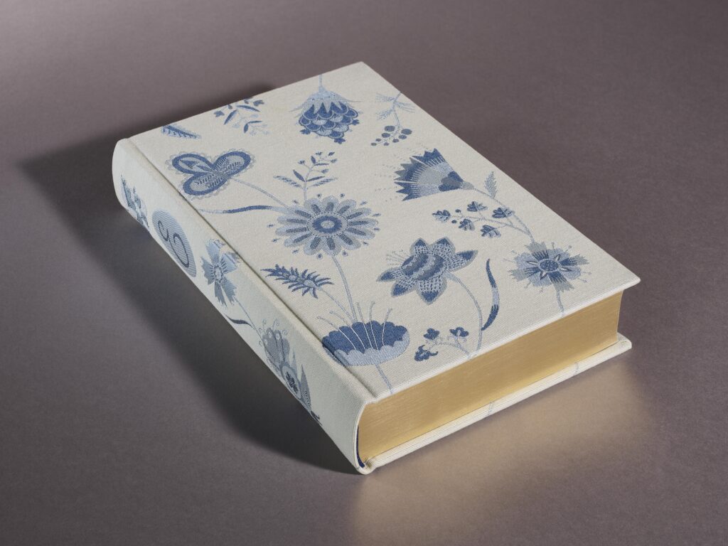One book from collection of Jane Austen covered in white fabric with blue motifs