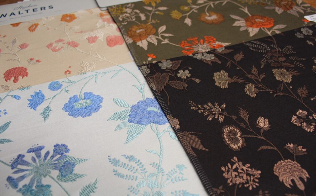 Delicate silk florals on the left orange and blue and the right brown and black laid side by side from the SS27 Stephen Walters Apparel collection.