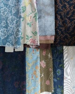 Selection of SS27 apparel blue, pink and khaki florals and a silver, white moire fabric