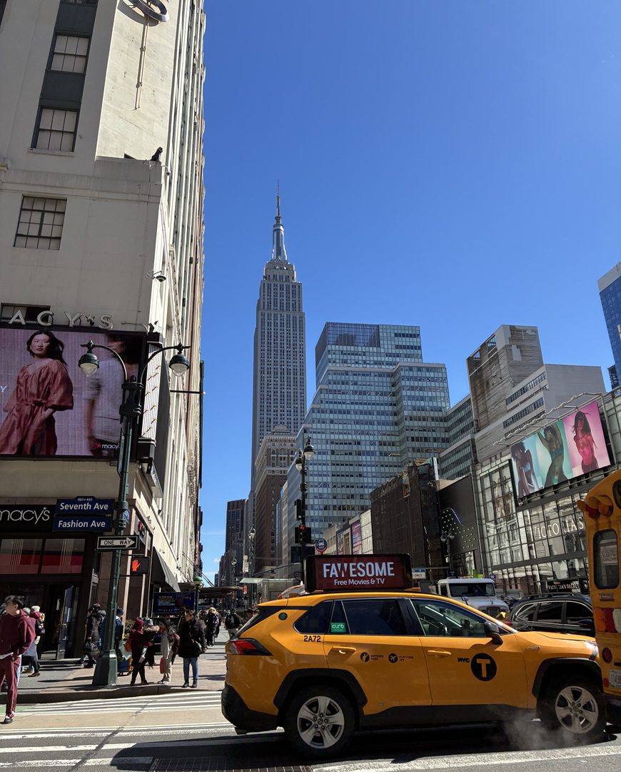 New York Skyline with a clear blue sky and a yellow taxi